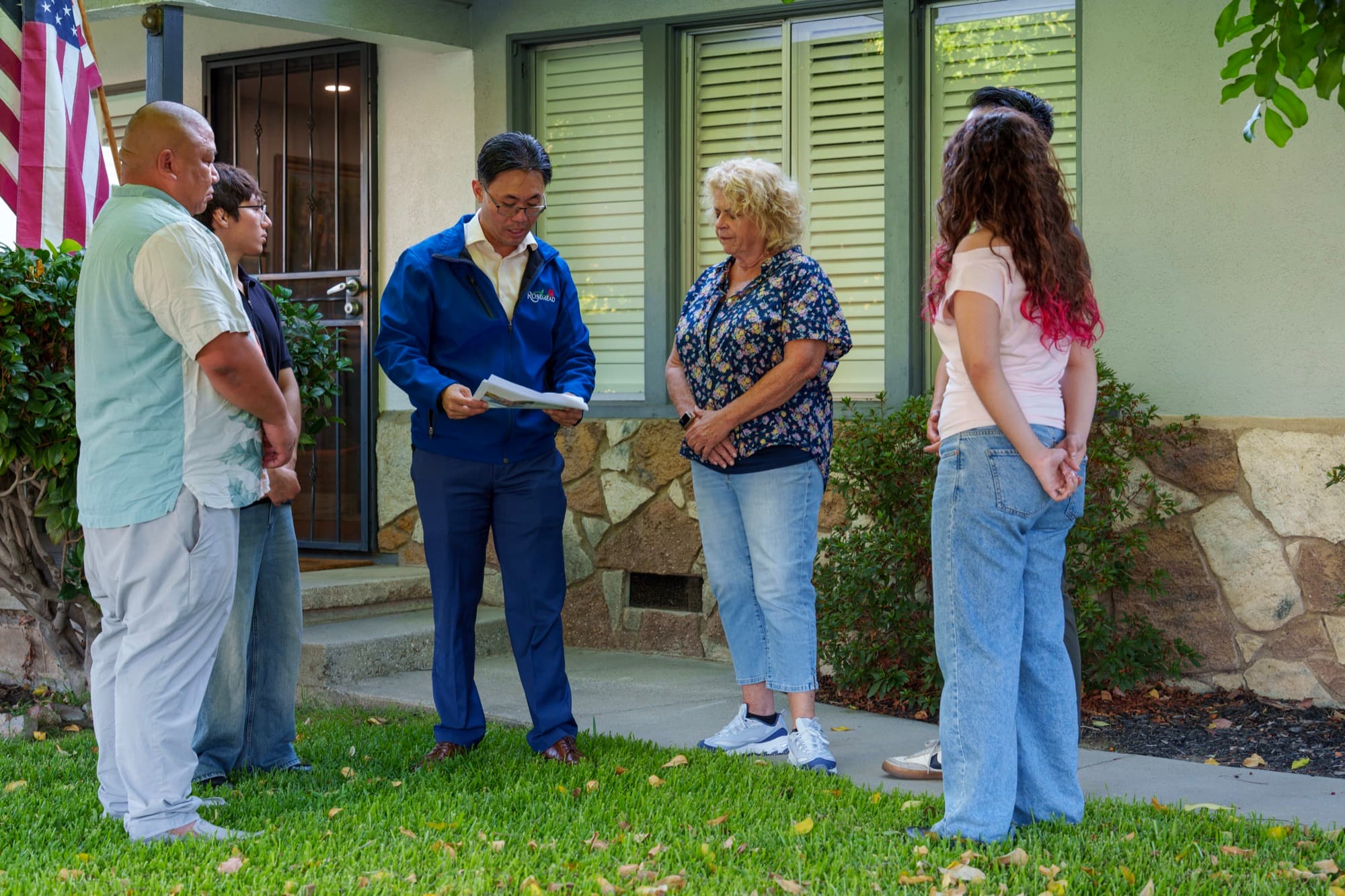 Steven Ly talking with Rosemead residents on a front lawn